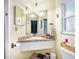 Charming bathroom with a granite countertop, decorative light fixtures, and a window for natural lighting at 1910 Sylvester Ct, Lakeland, FL 33803
