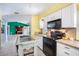 Bright kitchen with white cabinets, black appliances, and a view into the living space at 1910 Sylvester Ct, Lakeland, FL 33803