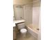 Bright bathroom featuring a toilet, tub with white tile surround, and neutral floor tiles at 709 Secret Harbor Ln # 313, Lake Mary, FL 32746