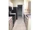 Kitchen with wooden cabinets, black appliances, and tile flooring at 709 Secret Harbor Ln # 313, Lake Mary, FL 32746