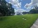 Green lawn stretches to a tranquil lake with a dock, creating a peaceful waterfront setting at 808 Edgewater Dr, Orlando, FL 32804