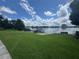 Expansive green lawn leading to a private dock on a serene lake under a cloudy sky at 808 Edgewater Dr, Orlando, FL 32804