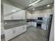 Modern kitchen featuring sleek white cabinetry, stainless steel appliances, and stylish backsplash at 808 Edgewater Dr, Orlando, FL 32804