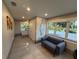Living room area with a grey loveseat, neutral paint, and large bright windows at 808 Edgewater Dr, Orlando, FL 32804