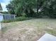 A large, grassy backyard with mature trees and garden at 1737 N Lakewood Ave, Ocoee, FL 34761