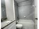 Clean bathroom with white tub, gray tile, and granite countertop at 1737 N Lakewood Ave, Ocoee, FL 34761