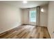 Comfortable bedroom with light-filled window and neutral color scheme with wood-look floors at 1737 N Lakewood Ave, Ocoee, FL 34761