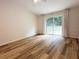 Spacious bedroom with wood-look floors, and a glass sliding door leading to the outside at 1737 N Lakewood Ave, Ocoee, FL 34761