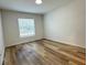 Cozy bedroom featuring wood-look floors, a window with blinds, and neutral walls at 1737 N Lakewood Ave, Ocoee, FL 34761