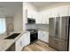 Close-up of kitchen showcasing granite countertops, stainless steel appliances, and white cabinetry at 1737 N Lakewood Ave, Ocoee, FL 34761