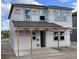 Two-story construction shows the house structure before siding. Windows are installed, with a covered porch at 2359 Zuni Road, St Cloud, FL 34771