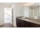 Bathroom featuring dark wood cabinets, granite countertops, a glass-enclosed shower, and a view into the bedroom at 1337 Dalkeith Cv, Sanford, FL 32771