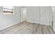Well lit bedroom with light gray wood floors, baseboard, and white walls at 5008 Vanguard St, Orlando, FL 32819