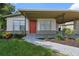 Charming single-story home with a red door, covered porch, and well-maintained landscaping at 5008 Vanguard St, Orlando, FL 32819