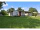 Charming single-story home with a well-maintained lawn and a welcoming covered porch and an orange colored front door at 5008 Vanguard St, Orlando, FL 32819