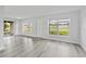 Bright living room with light gray wood floors and lots of natural light from the large windows at 5008 Vanguard St, Orlando, FL 32819