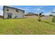 Backyard featuring a grass lawn, palm tree, and a beige fence at 623 Grove St, Winter Haven, FL 33881