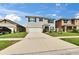 Well-maintained two-story home featuring a green lawn, blue shutters, and a two-car garage on a sunny day at 623 Grove St, Winter Haven, FL 33881