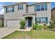 Inviting two-story home features a well-manicured lawn with vibrant flowering bushes and crisp, dark shutters at 623 Grove St, Winter Haven, FL 33881