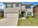 Beautiful two-story home with a lush green lawn, neat landscaping, dark shutters, and a two-car garage at 623 Grove St, Winter Haven, FL 33881