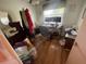 A cluttered bedroom featuring hardwood floors, natural light, and potential for a cozy personal space at 7175 Se 123Rd Pl, Belleview, FL 34420