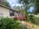 Charming home featuring a red deck and lush landscaping in the front yard at 7175 Se 123Rd Pl, Belleview, FL 34420