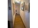 Hallway with wood floors and pictures on the wall at 7175 Se 123Rd Pl, Belleview, FL 34420