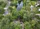 Aerial view of the property and neighborhood featuring mature trees, a water fountain, and a swimming pool at 116 Winding Oaks Ln, Oviedo, FL 32765