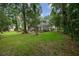 A large backyard featuring a screened in patio, mature trees, and lush green grass at 116 Winding Oaks Ln, Oviedo, FL 32765