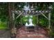Relaxing backyard seating area under a pergola overlooking the fountain and lake at 116 Winding Oaks Ln, Oviedo, FL 32765