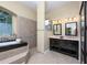 Main bathroom featuring dual vanities, soaking tub, and walk-in shower at 116 Winding Oaks Ln, Oviedo, FL 32765