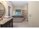 Main bathroom with steps up to the soaking tub and a tiled walk-in shower at 116 Winding Oaks Ln, Oviedo, FL 32765