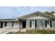 Charming home featuring a stone accent facade, black shutters, and a modern black door at 1420 Wood Ave, Haines City, FL 33844