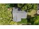 Aerial view of a house featuring a dark gray shingled roof surrounded by lush green trees at 530 S Eola Dr, Orlando, FL 32801