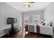 Bedroom with ceiling fan, windows, hardwood floors, and television at 530 S Eola Dr, Orlando, FL 32801