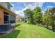 A lush green lawn stretches out from the back of the home, surrounded by mature trees at 4034 Winding Vine Dr, Lakeland, FL 33812