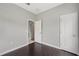 Neutral bedroom with wood-look flooring, white trim, and two access doors at 4034 Winding Vine Dr, Lakeland, FL 33812