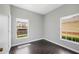 Bedroom with wood-look flooring, neutral walls, and two windows that provide natural light at 4034 Winding Vine Dr, Lakeland, FL 33812