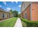 Manicured lawn leads up to a two-story home with green bushes and orange accent around the exterior at 4034 Winding Vine Dr, Lakeland, FL 33812