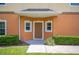 Exterior entrance with a brown front door, manicured lawn and minimal garden at 4034 Winding Vine Dr, Lakeland, FL 33812