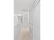Hallway featuring plush carpet, neutral walls, a linen closet, and multiple access doors at 4034 Winding Vine Dr, Lakeland, FL 33812