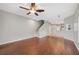 Open-concept living room featuring wood-look floors, a ceiling fan, and a staircase to the upper level at 4034 Winding Vine Dr, Lakeland, FL 33812