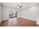 Bright living room with wood-look flooring, ceiling fan, and sliding glass doors to the screened-in patio at 4034 Winding Vine Dr, Lakeland, FL 33812
