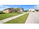 Landscaped front yard and a sidewalk of a one story home on a sunny day in a quiet neighborhood at 4710 Osprey Way, Winter Haven, FL 33881