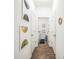 Hallway with modern decor leading to the laundry room, featuring wood floors and crisp white walls at 4710 Osprey Way, Winter Haven, FL 33881