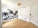 Bright bedroom featuring a palm tree wall design and blonde laminate flooring at 132 Canary Island Cir, Davenport, FL 33837