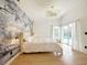 Bright bedroom with a decorative chandelier, natural light, wood floors, and a pool view at 132 Canary Island Cir, Davenport, FL 33837