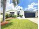 Beautiful single-story home with a well-manicured lawn and black-trimmed facade in a sunny setting at 132 Canary Island Cir, Davenport, FL 33837
