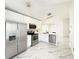 Contemporary kitchen with stainless steel appliances, white cabinets, quartz countertops, and marble floors at 132 Canary Island Cir, Davenport, FL 33837
