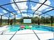 Enclosed pool with floating toys and a view of the lush green backyard at 132 Canary Island Cir, Davenport, FL 33837